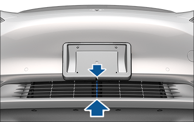 Arrows showing to align the bottom center of the license plate with the middle of the grille.