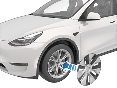 Aero cover's Tesla "T" aligned with tire's valve stem with an arrow pointing from the cover to the tire